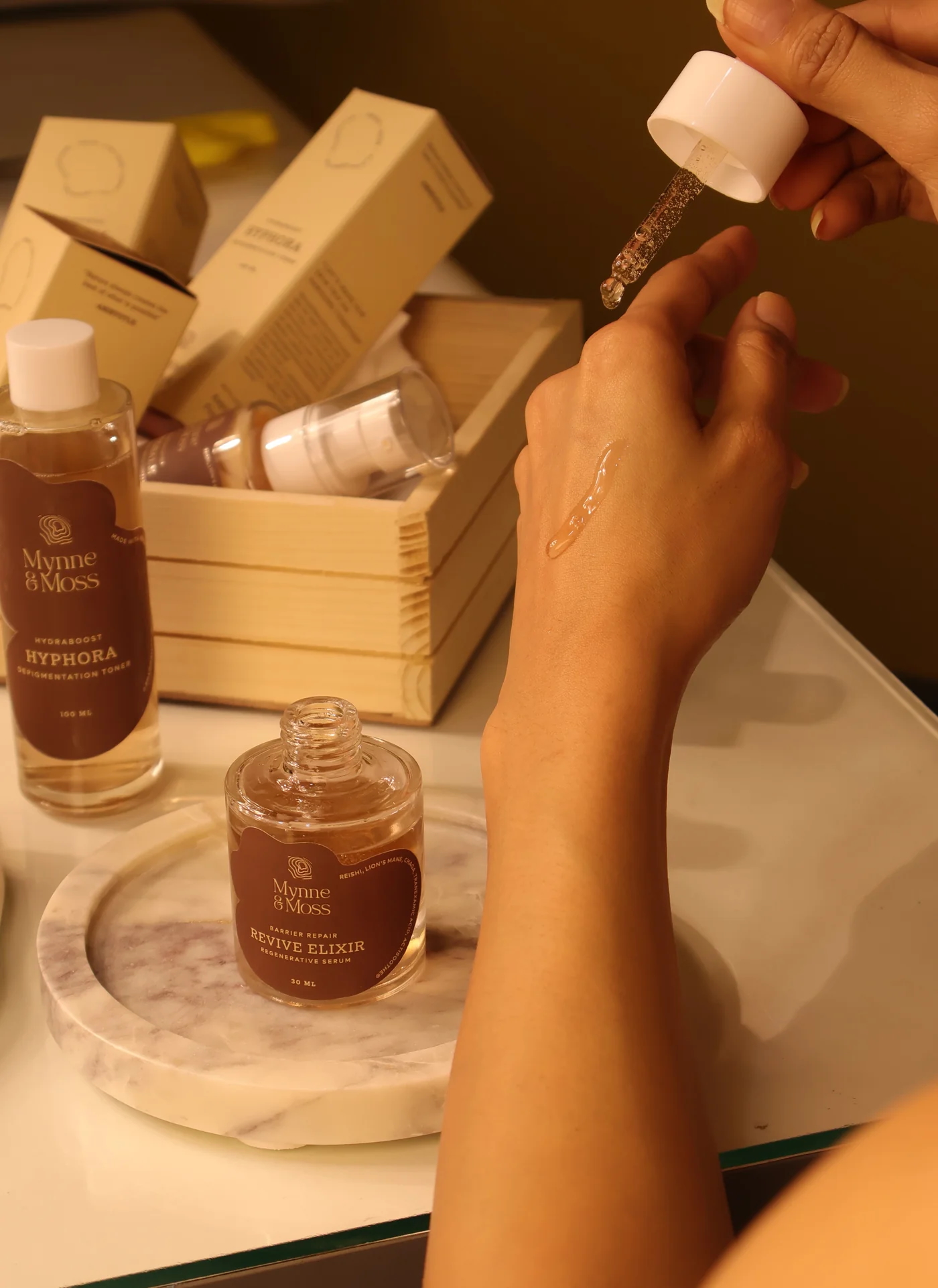 Applying Revive Elixir serum from the dropper onto skin